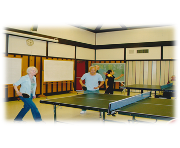 image of elderly people playing ping pong in a rec center