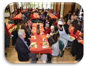 image of people sitting at long communal tables eating a meal